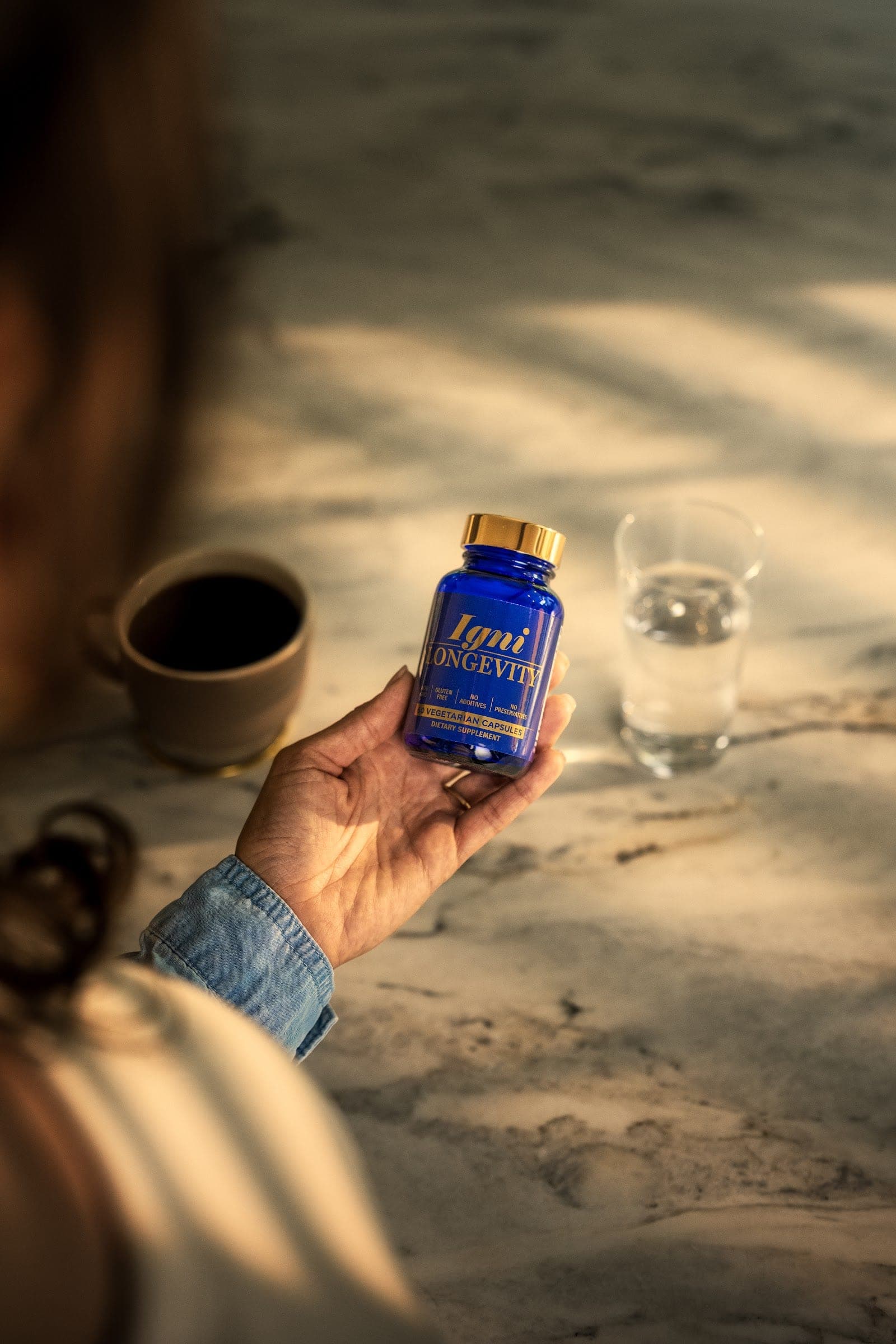 An Igniton supplement held in warm natural light — premium daily ritual